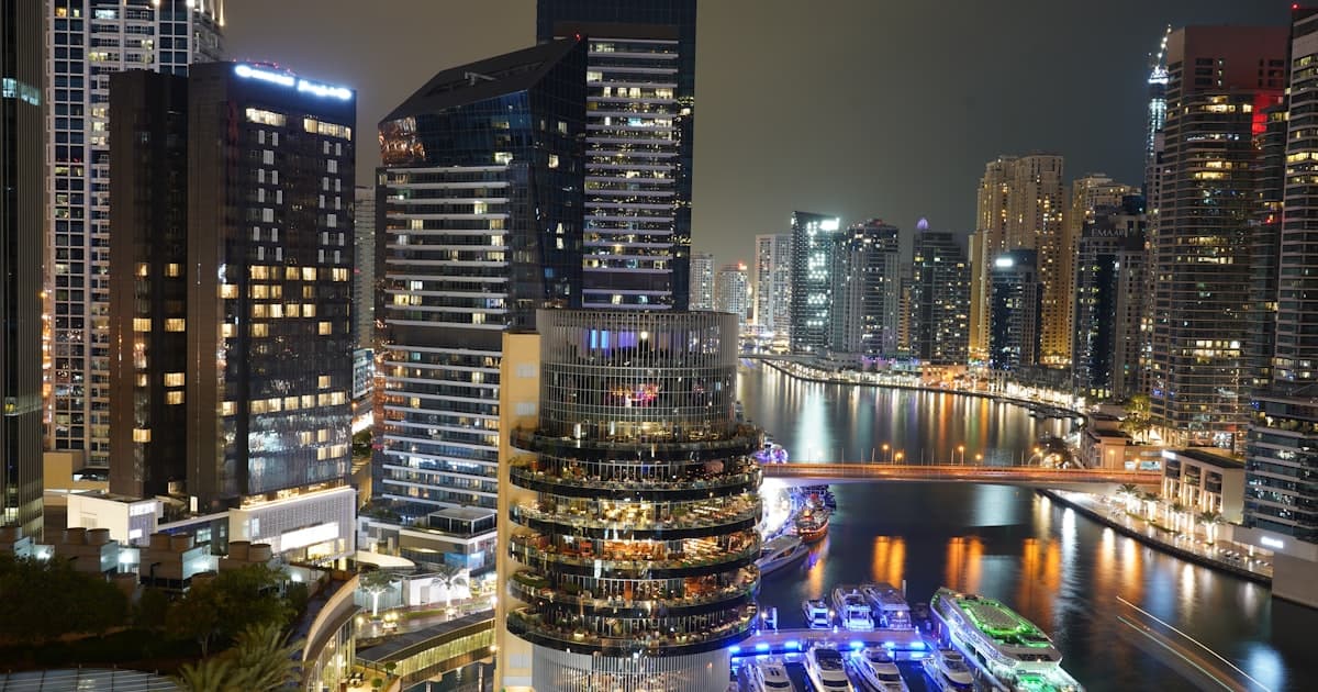 Dubai Marina skyline at night with waterfront towers and reflections
