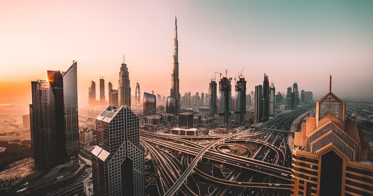 Aerial view of Dubai city highway surrounded by high-rise buildings at sunrise